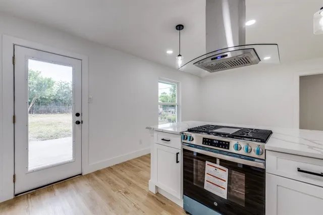 a kitchen with a sink cabinets and wooden floor