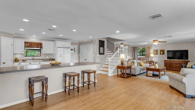 a large living room with stainless steel appliances kitchen island granite countertop a couch and a view of living room