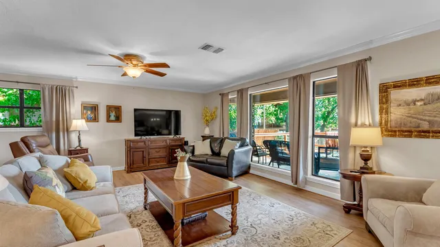 a living room with furniture a flat screen tv and a large window