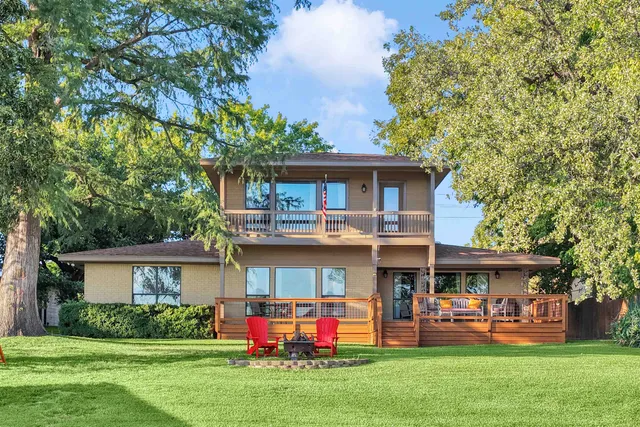 a front view of a house with a yard and trees