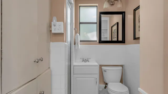 a bathroom with a toilet a sink and mirror
