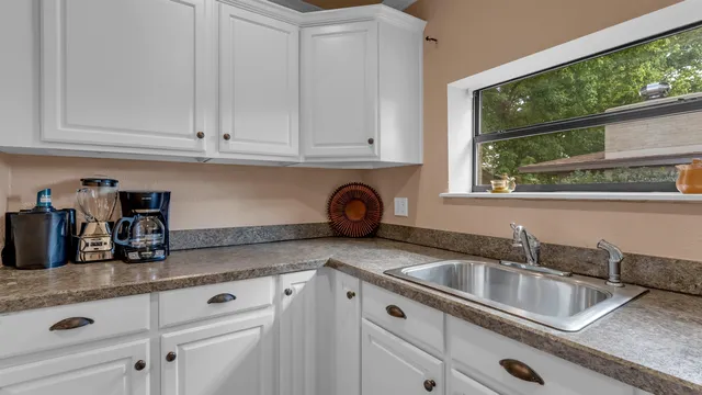 a kitchen with granite countertop a sink and cabinets