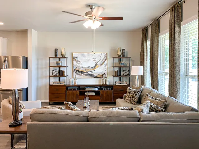 a living room with furniture a flat screen tv and a large window