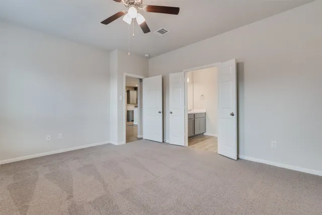 a view of empty room with ceiling fan