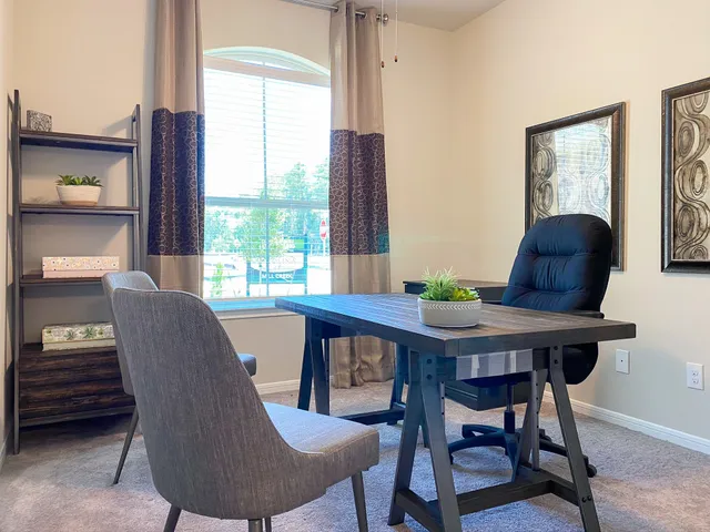 a view of a dining room with furniture and a window