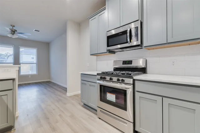 a kitchen with stainless steel appliances a stove microwave and sink