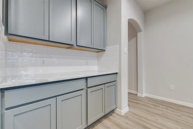 a kitchen with cabinets and wooden floor