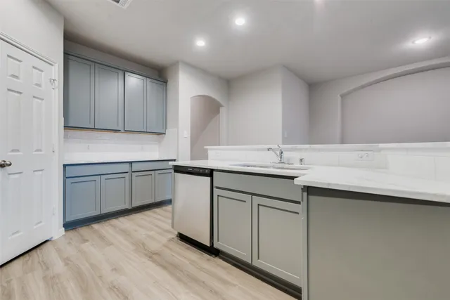 a kitchen with a sink cabinets and wooden floor