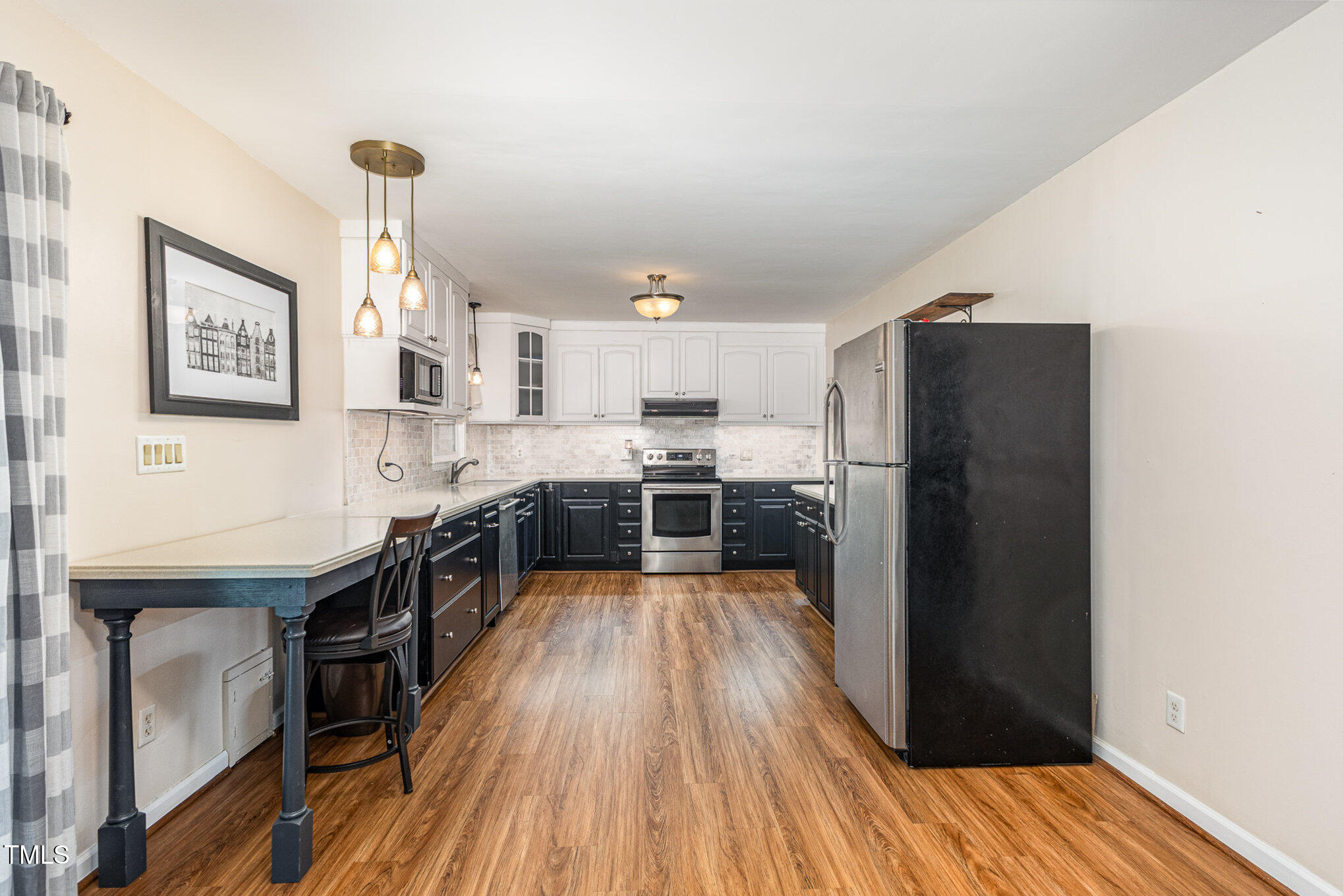 6609 Electra Drive Raleigh, NC 27607 - Photo 12 of 35 a kitchen with stainless steel appliances a refrigerator and a wooden floor