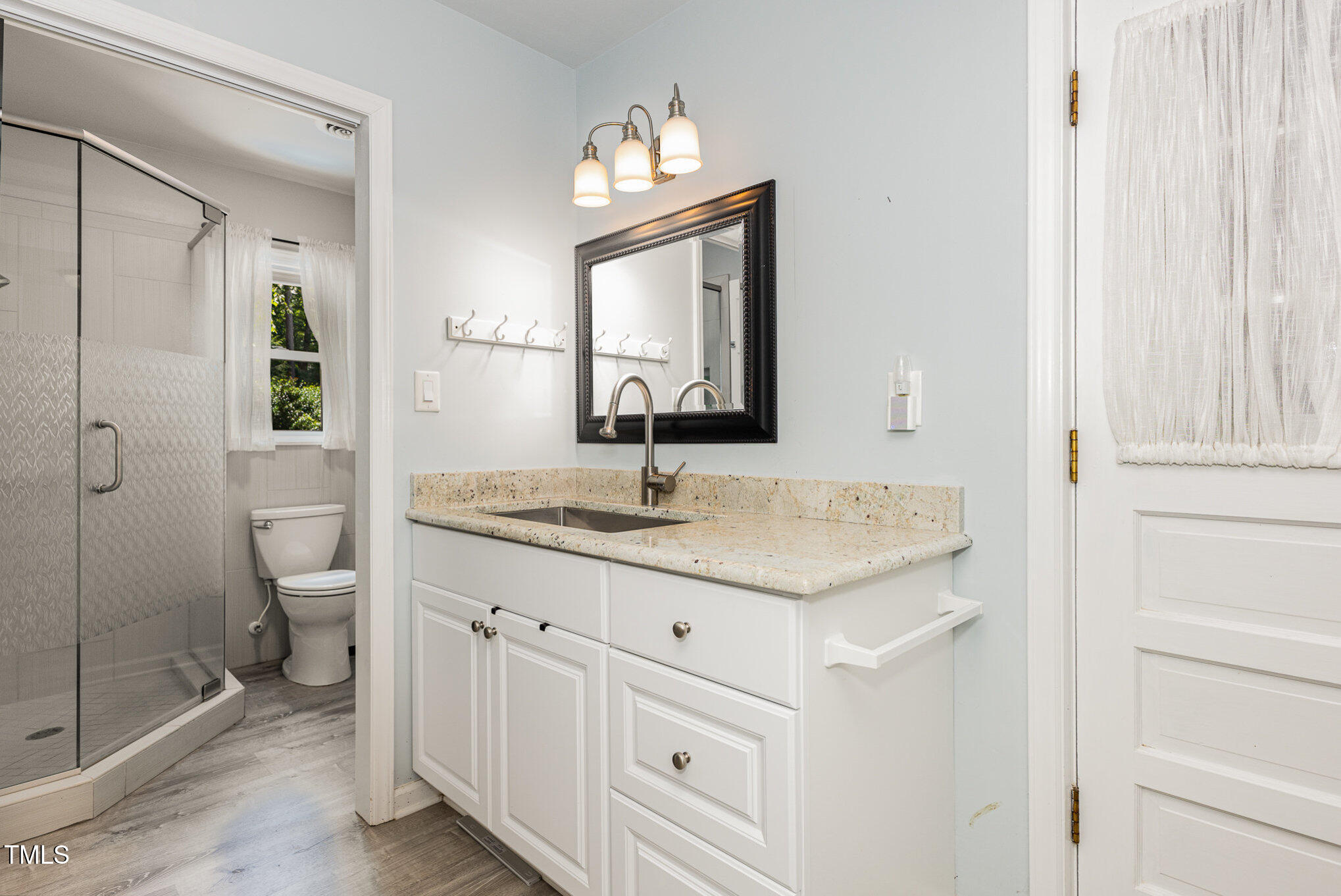 6609 Electra Drive Raleigh, NC 27607 - Photo 21 of 35 a bathroom with a granite countertop sink a toilet and a mirror
