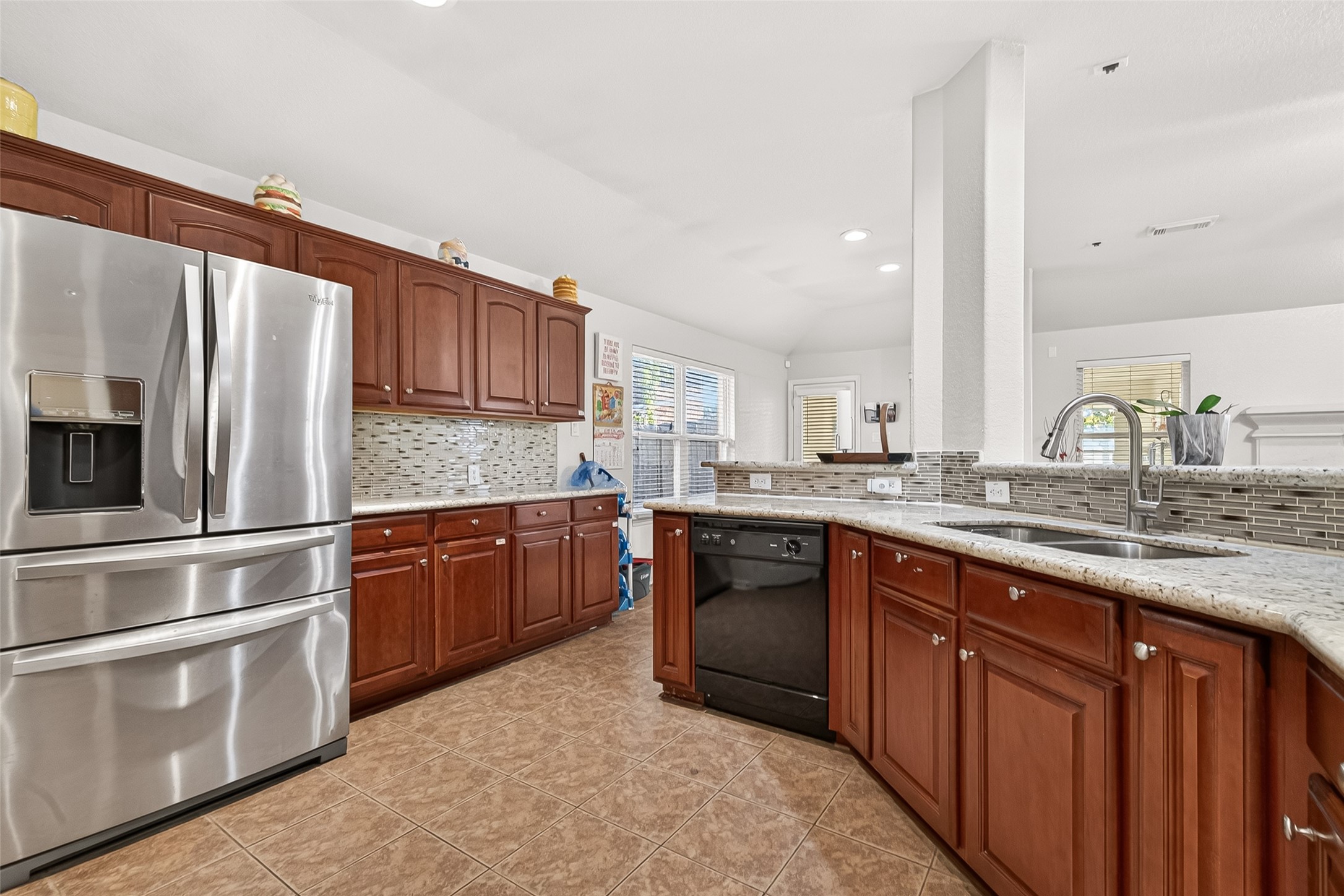 16715 Mackenzie Mesa Drive Spring, TX 77379 - Photo 14 of 50 a kitchen with stainless steel appliances granite countertop a refrigerator and wooden cabinets