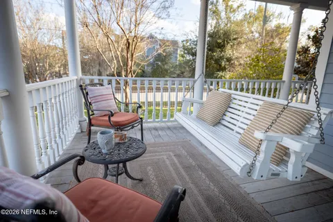 a view of a patio with table and chairs under an umbrella with wooden fence
