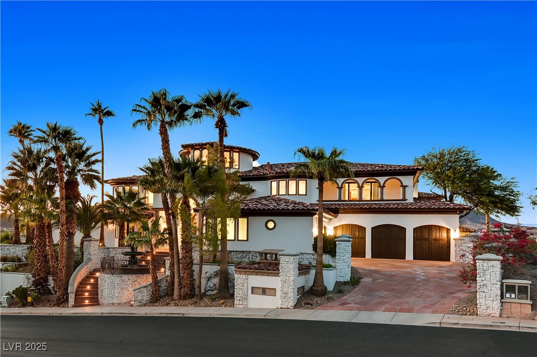 Mediterranean / spanish-style home featuring stucco siding, decorative driveway, and a tile roof