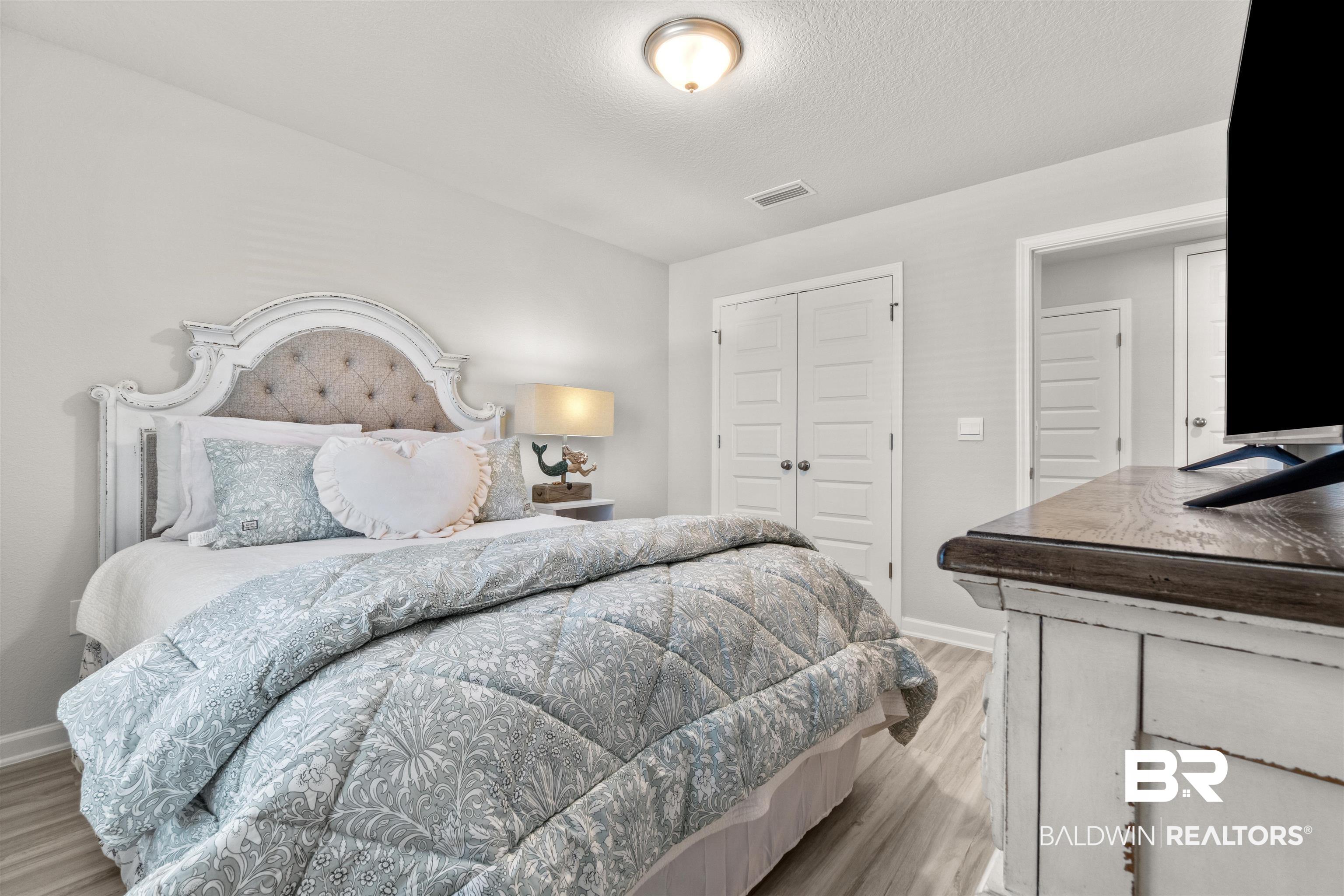 24472 Ringneck Loop Elberta, AL 36530 - Photo 33 of 46 Bedroom featuring light hardwood / wood-style floors, a textured ceiling, and a closet