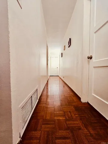 a view of a hallway with wooden floor