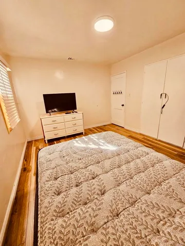 a bedroom with a bed and a flat screen tv
