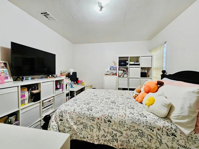 a bedroom with a bed and a flat screen tv