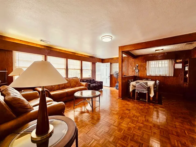 a living room with furniture a rug and a floor to ceiling window
