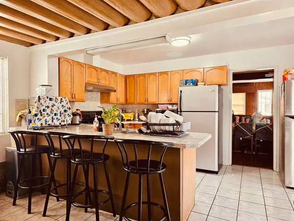 a kitchen with stainless steel appliances a table chairs and a refrigerator