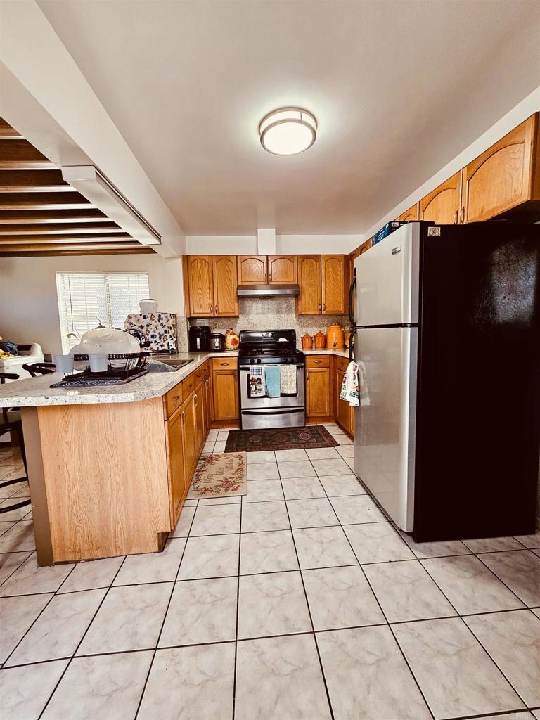 3333 Delta Avenue Long Beach, CA 90810 - Photo 8 of 31 a kitchen with stainless steel appliances granite countertop a stove a sink and a refrigerator