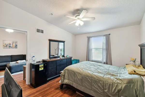 a bedroom with a bed and wooden floor