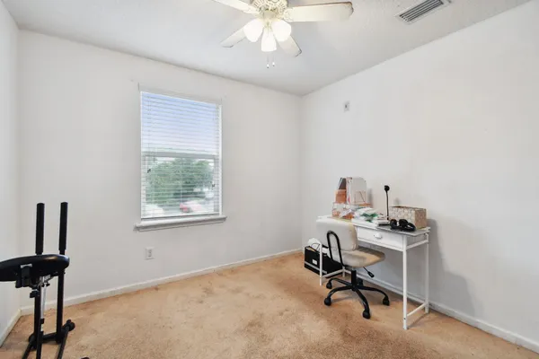 a view of a workspace with furniture and a window