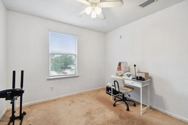 a view of a workspace with furniture and a window