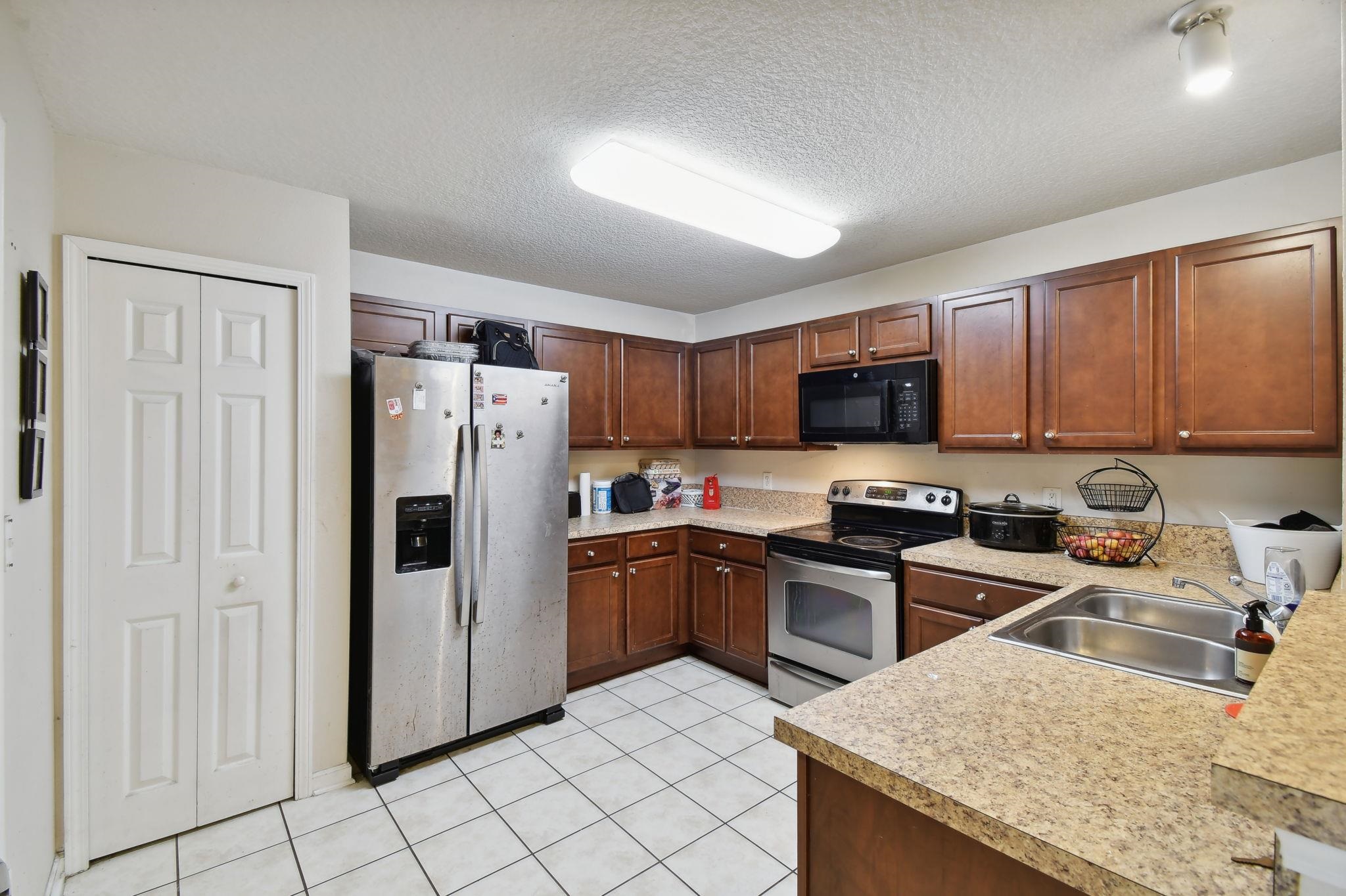 2481 Golden Lake Loop St. Augustine, FL 32084 - Photo 7 of 39 a kitchen with stainless steel appliances granite countertop a refrigerator stove microwave and sink