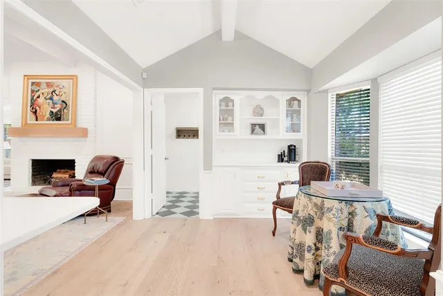 a living room with furniture a fireplace and next to a window