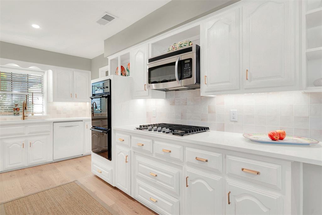 1601 Geneva Lane Plano, TX 75075 - Photo 8 of 38 a kitchen with stainless steel appliances white cabinets and a stove
