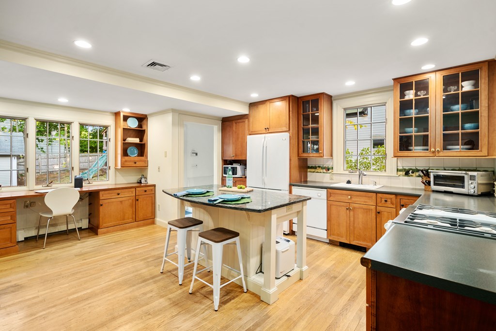 34 Upland Road Newton, MA 02468 - Photo 12 of 33 a kitchen with stainless steel appliances granite countertop a stove top oven a sink dishwasher and white cabinets with wooden floor