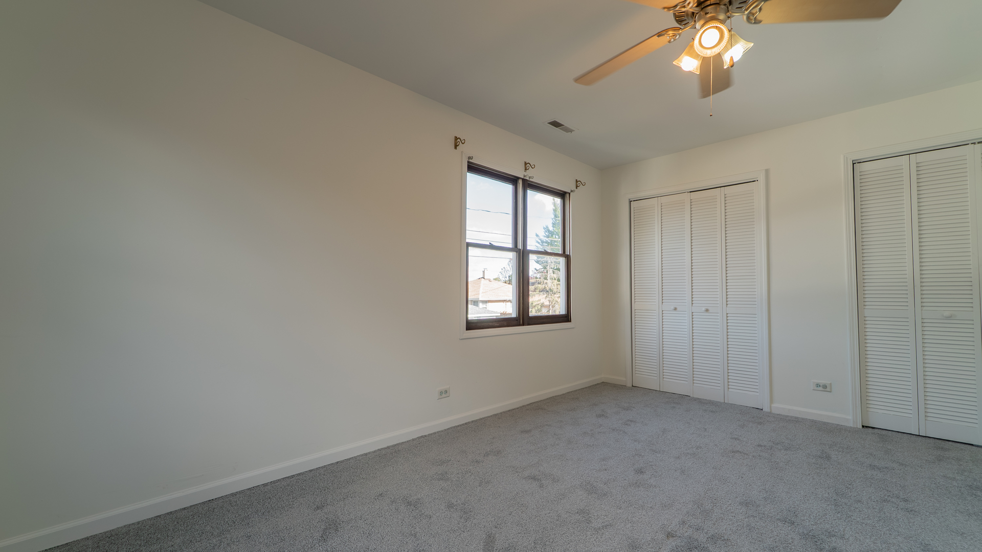 122 Elizabeth Street Calumet City, IL 60409 - Photo 16 of 31 an empty room with a chandelier fan and windows