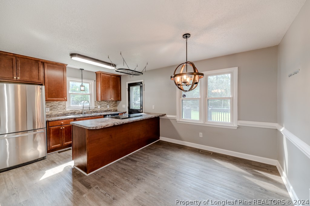 925 Line Road Cameron, NC 28326 - Photo 11 of 42 a large kitchen with stainless steel appliances granite countertop a refrigerator a stove a sink dishwasher and a dining table with wooden floor