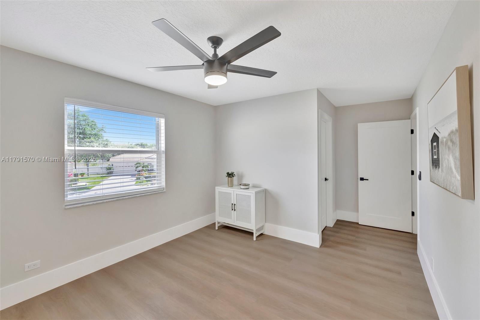 6393 Brava Way Boca Raton, FL 33433 - Photo 32 of 55 an empty room with wooden floor and windows