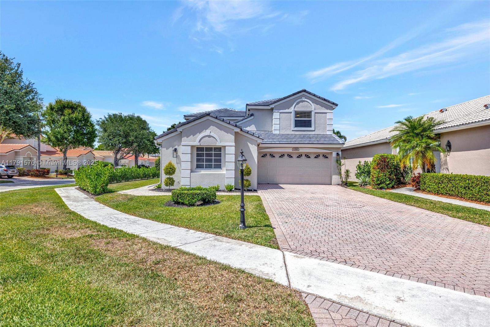 6393 Brava Way Boca Raton, FL 33433 - Photo 38 of 55 a front view of a house with a yard