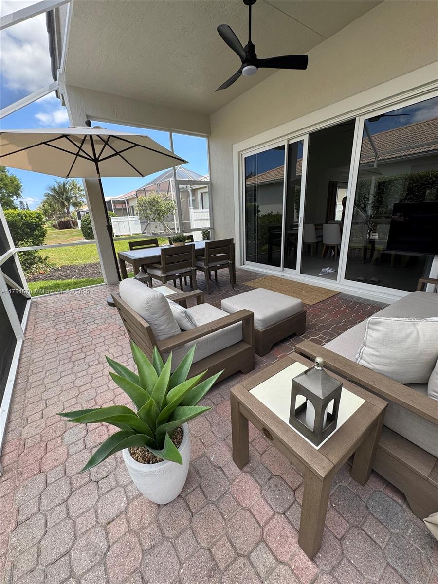 6393 Brava Way Boca Raton, FL 33433 - Photo 39 of 55 a living room with patio furniture and a floor to ceiling window