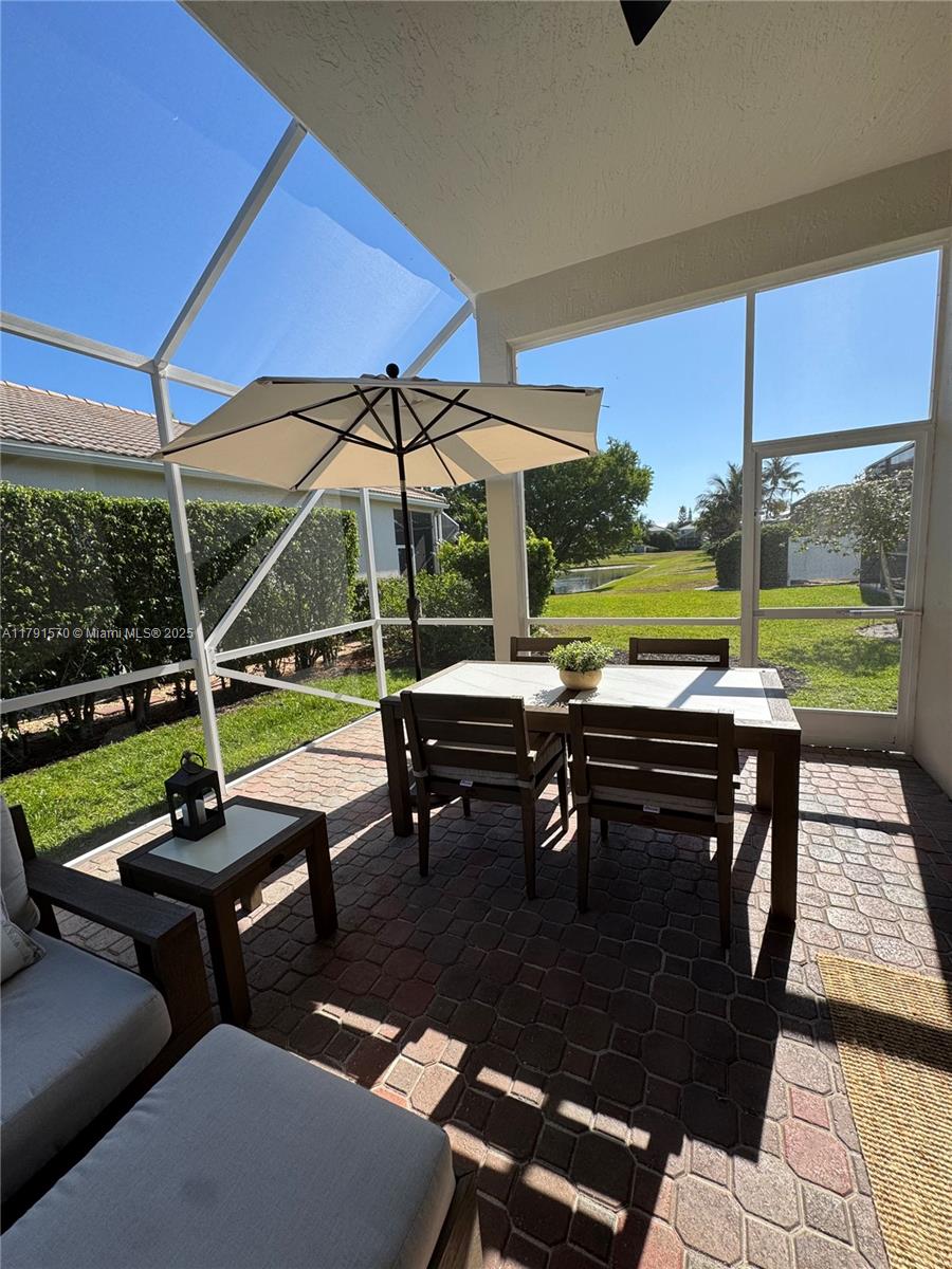 6393 Brava Way Boca Raton, FL 33433 - Photo 42 of 55 a view of a swimming pool with a table and chairs under an umbrella