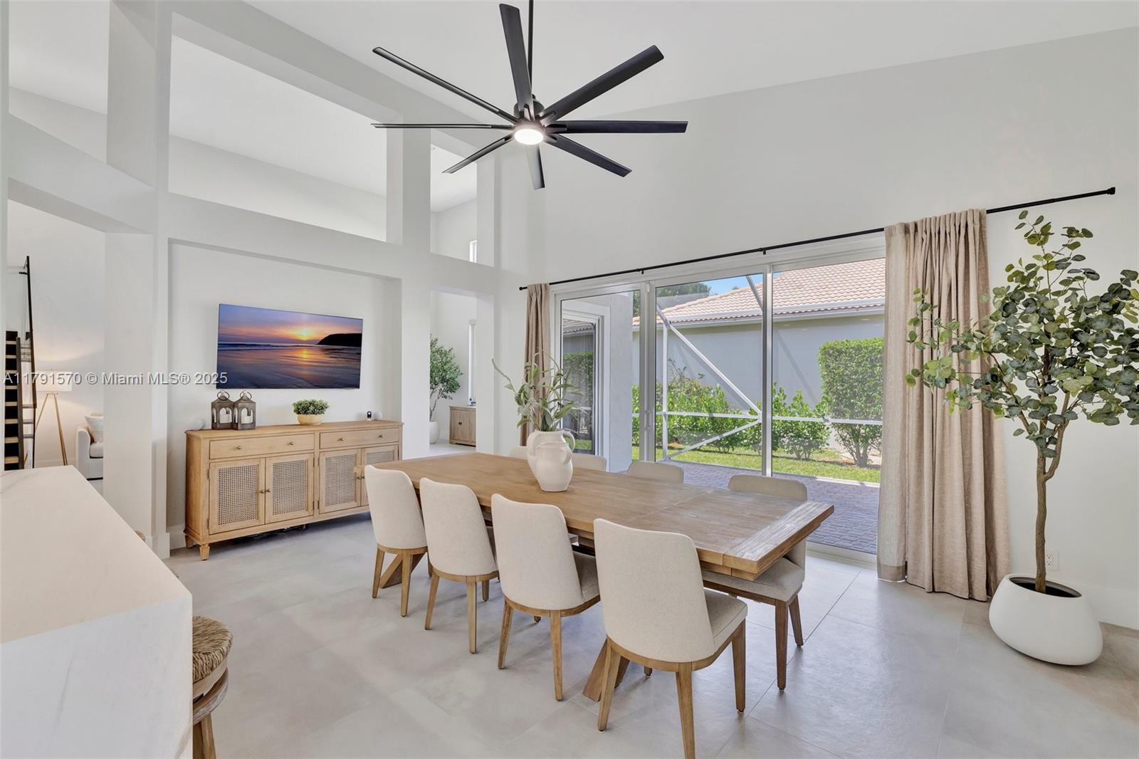 6393 Brava Way Boca Raton, FL 33433 - Photo 8 of 55 a dining room with furniture a flat screen tv and a large window