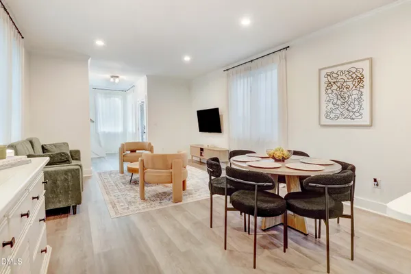 a kitchen with stainless steel appliances granite countertop a refrigerator a sink dishwasher a stove and white cabinets with wooden floor