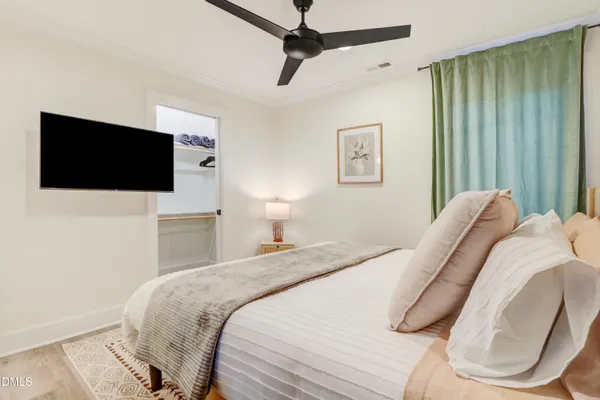 a bedroom with a white bed and a painting on the wall