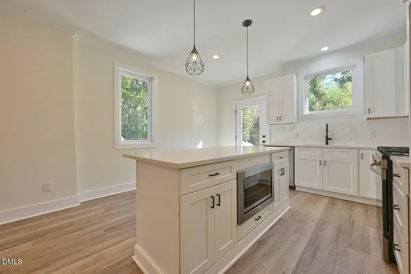 a kitchen with white cabinets and sink