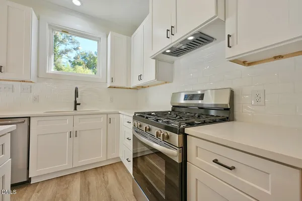 a kitchen with cabinets appliances and a window