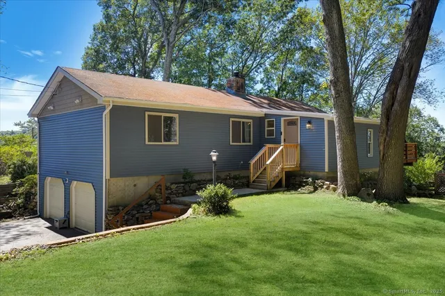 a view of backyard with table and chairs and a large tree