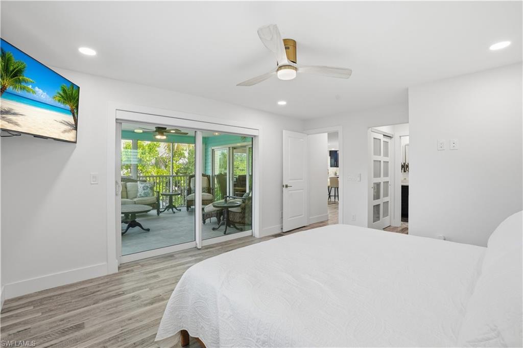 270 Dundee Road Fort Myers Beach, FL 33931 - Photo 21 of 48 Bedroom featuring light wood-style flooring, ceiling fan, recessed lighting, and access to exterior - Virtually Edited Image