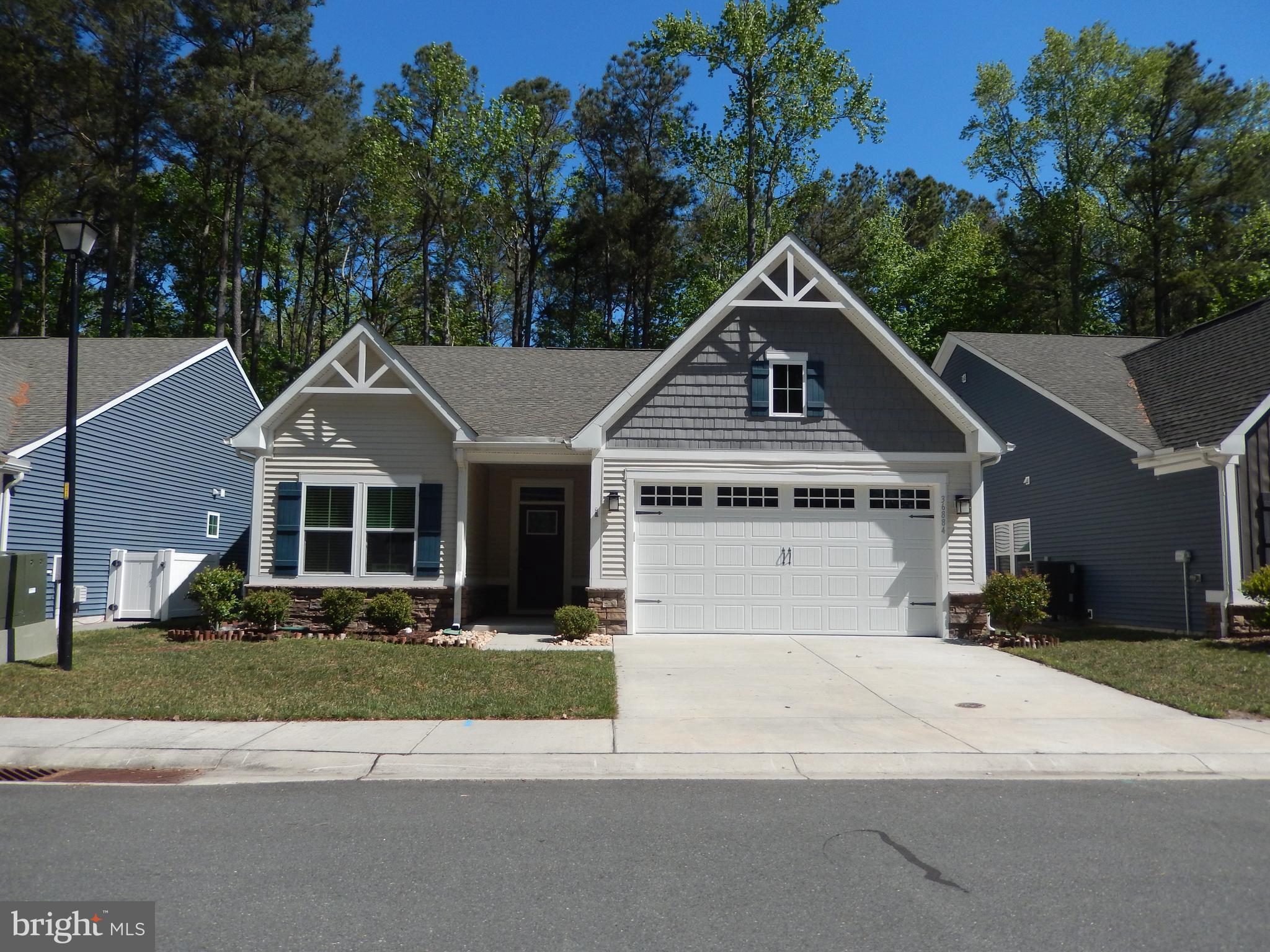 36884 Red Cedar Loop Ocean View, DE 19970 - Photo 43 of 50 a view of a white house with a big yard and large trees