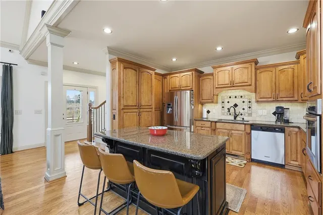 a kitchen with stainless steel appliances granite countertop a refrigerator a stove and a sink