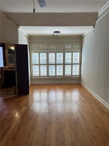 a view of empty room with wooden floor