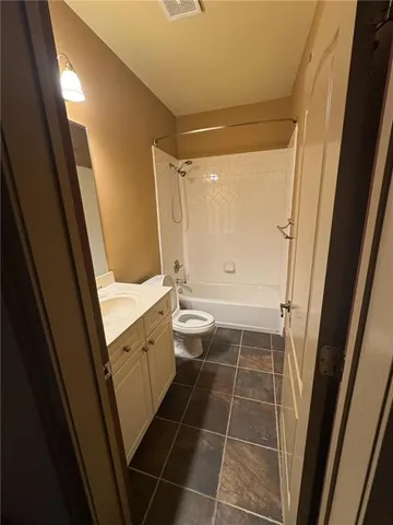 a view of a brick house next to a yard