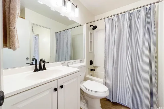a bathroom with a sink a toilet and shower curtain