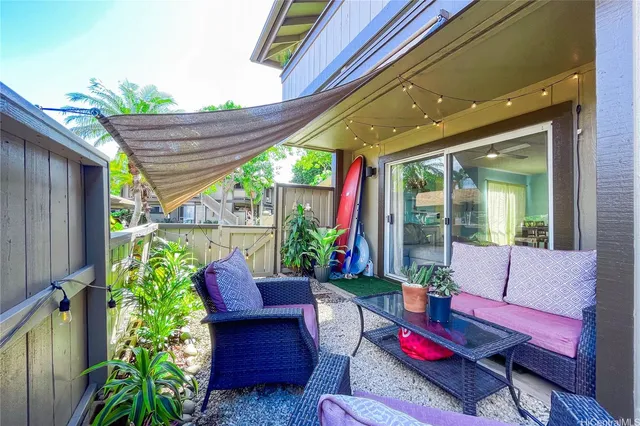 a patio with patio couch and a potted plant